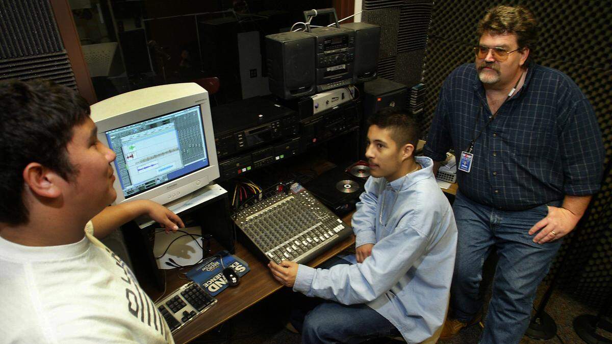 Ed Dailey, far right, a teacher at the Tri-Tech Skills Center in Kennewick, listens to students make a radio commercial in the school’s sound studio in 2004. Dailey helped many of his students start careers in music and radio.