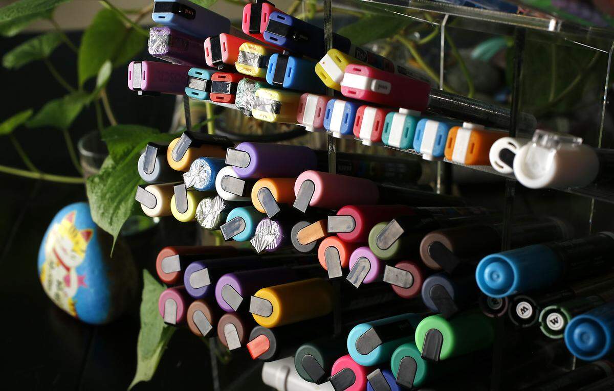 Rock painter Lynnette Gallegos uses paint pens at her dining room table in her Kennewick home to work on her creations.