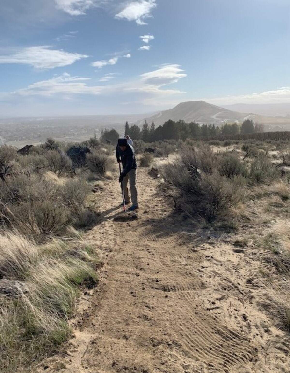 A volunteer with the Friends of Badger Mountain work on development of the new Little Badger Mountain trail. 
