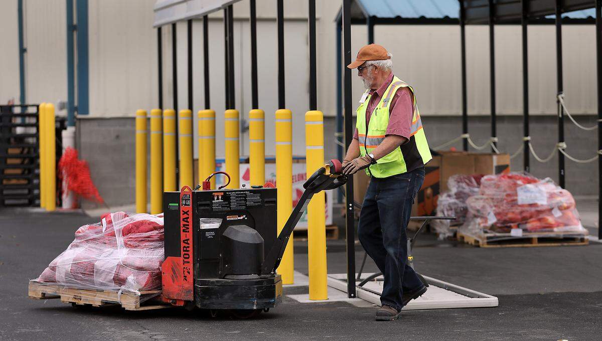 Volunteer Tim Flaten positions a pallet of potatoes under an awning Monday in preparation for Wednesday's food distribution.