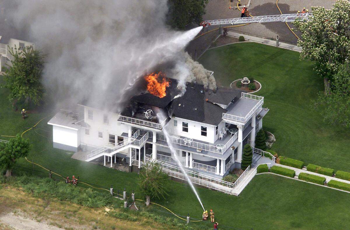 The Moore Mansion, a Pasco landmark along the Columbia River, burns in May 2001 as firefighters spray water on flames shooting through the roof. The vintage building was heavily damaged in the three-alarm blaze.
