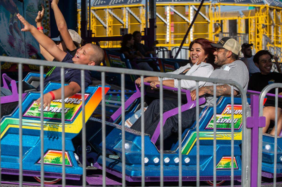 Heidi and Joe Leyva of Pasco laugh as they take a spin on the Pineapple Express at the Benton Franklin Fair & Rodeo. 