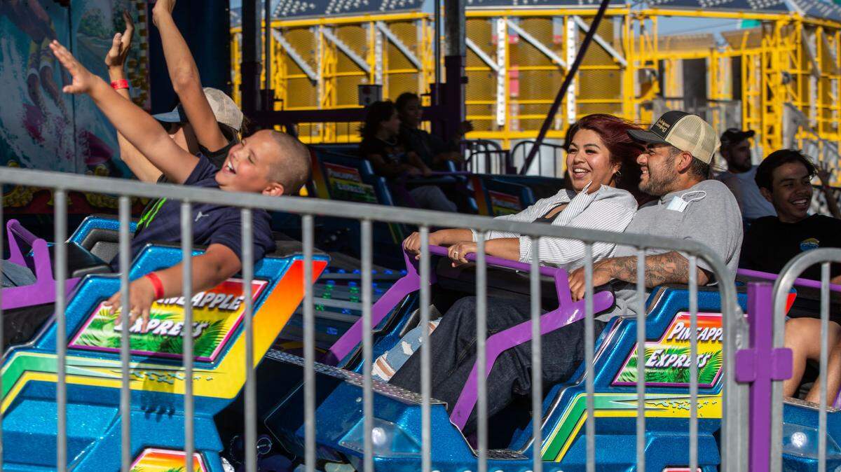 Heidi and Joe Leyva of Pasco laugh as they take a spin on the Pineapple Express at the 2021 Benton Franklin Fair & Rodeo.
