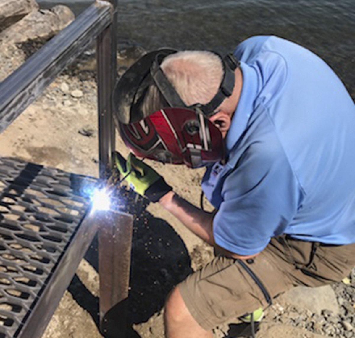 Volunteer Clarence Martin, 76, welds a section of the replacement steel dock walkway recently for the upcoming Tri-Cities Water Follies boat racing event in Columbia Park.