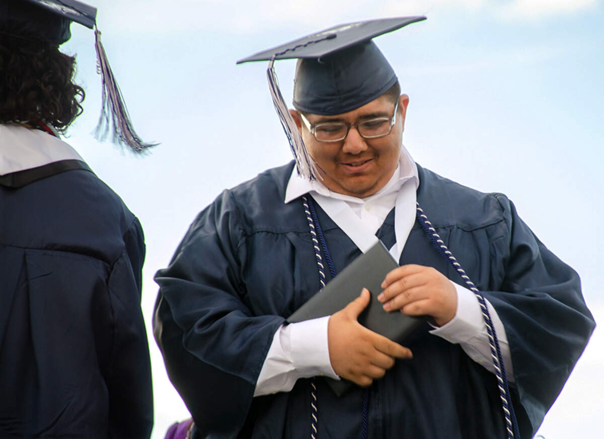 Salvador Camacho Campos cradles his diploma walking off the stage Saturday, June 6, at Edgar Brown Stadium. He says he graduated high school for himself, for his family and for his late mother, who he knew was watching over him.