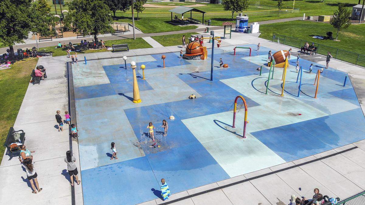 Families cool off at Badger Mountain Community Park’s splash park in Richland on Tuesday. The high reached 106 in Pasco by the afternoon. The National Weather Service said it will be sunny and hot again Wednesday but a little cooler with highs near 98.
