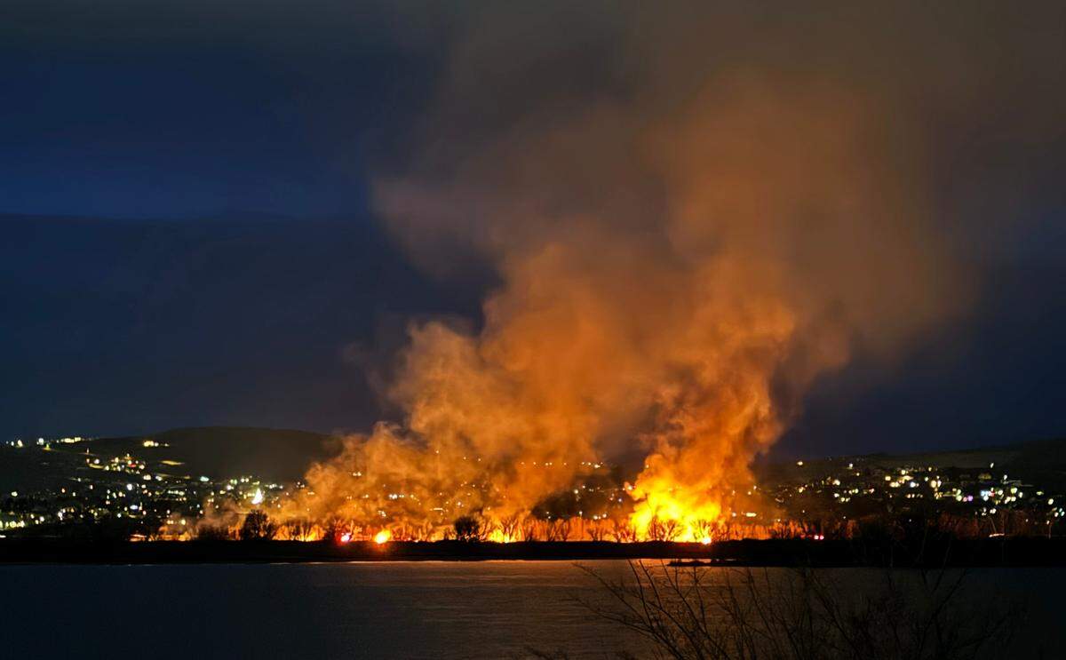 Smoke and flames fill Sunday’s early morning sky from a brush fire in the Yakima River Delta in Richland.