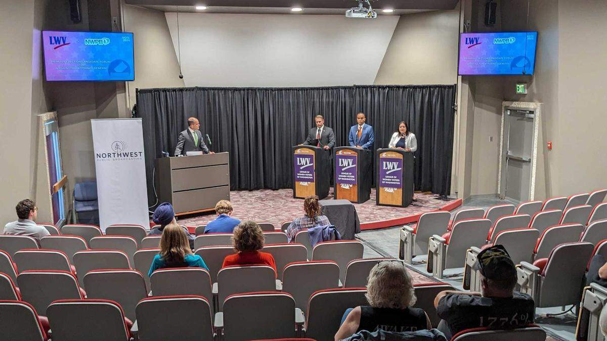 Matt Loveless, assistant professor of communications at Washington State University, left, moderates a 2024 forum at WSU Tri-Cities in Richland with three candidates running for Washington state attorney general.