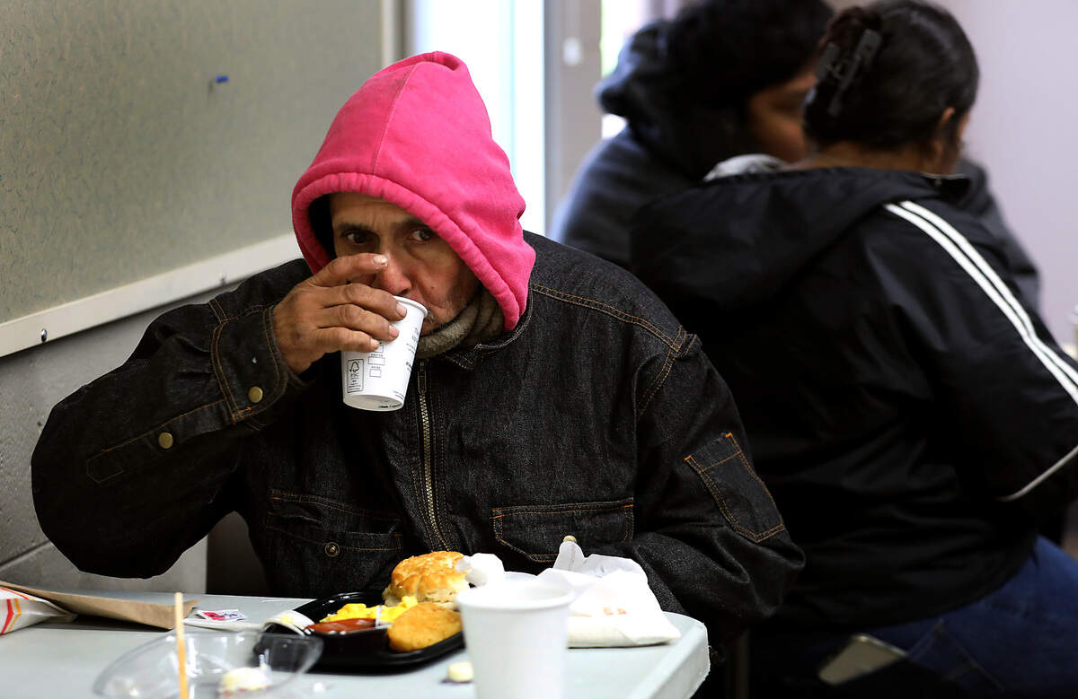 Leonard Ramirez, 53, sips a cup of hot coffee while eating a warm breakfast. Kadlec partners with other local organizations to host the monthly outreach event for those in need.