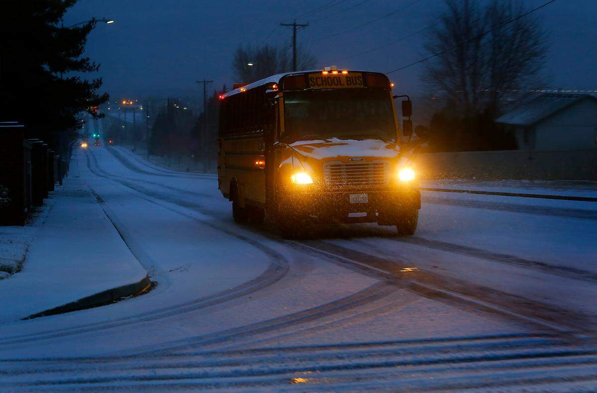 A Kennewick School District bus makes its way up snow covered South Ely Street in Kennewick early Wednesday morning after an overnight snow storm coated the Tri-Cities in the frozen precipitation.