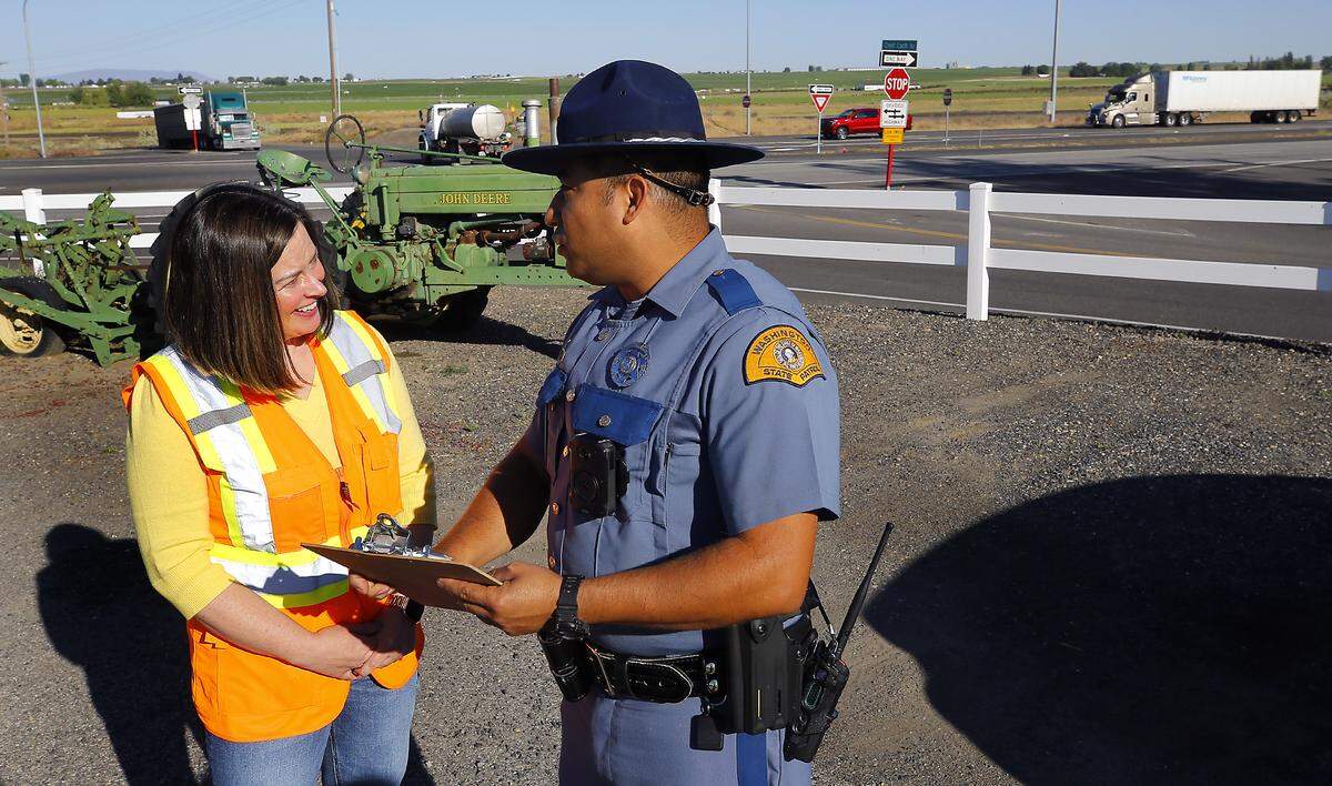 Meagan Lott, Washington State Department of Transportation communications manager, and Washington State Patrol trooper Daniel Mosqueda prepare to speak Thursday morning about the safety emphasis measures that have been implemented on Highway 395 north of Pasco.