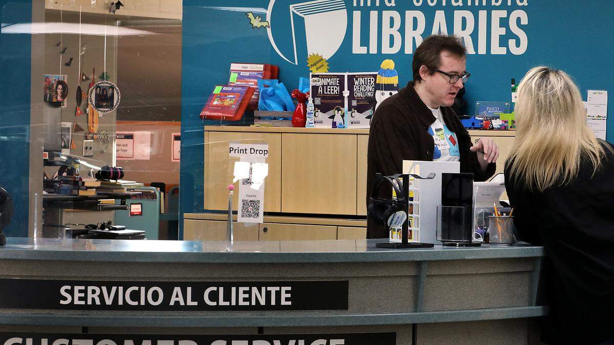 Librarian Russell Brandon helps a patron at The Mid-Columbia Libraries' Pasco Branch. It's the second largest branch of the library system's 12 branches and offers a large selection of English and Spanish language books and materials for all ages including DVDs and magazines.