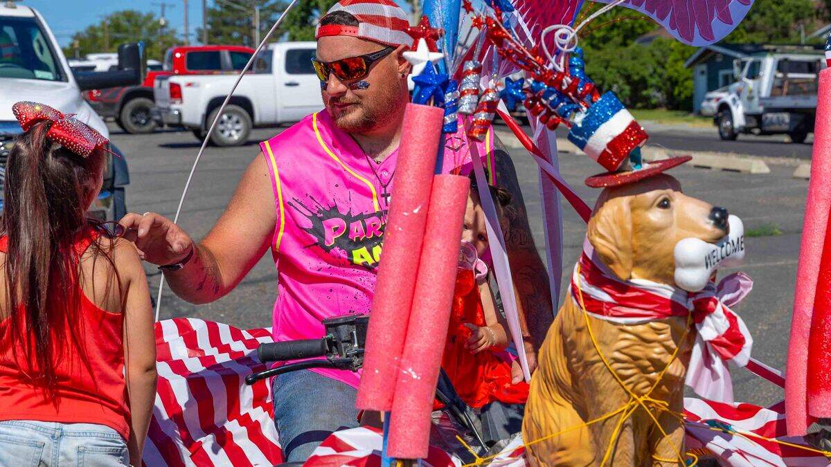 A family rides a patriotic-themed parade entry Saturday during the Benton City Fourth of July Parade. Decorated with red, white and blue bunting, the entry reflected the hometown spirit of the annual Independence Day celebration.