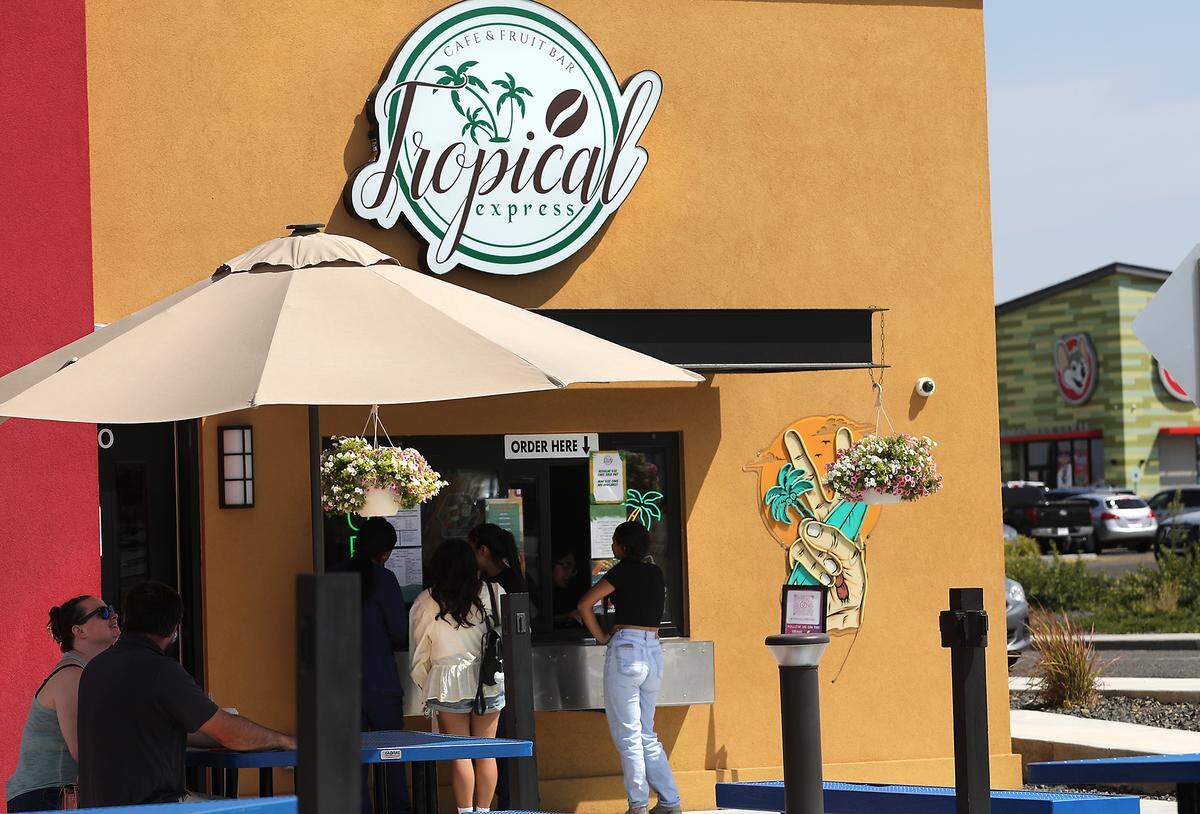 Customers line up at the outdoor walkup order window at the Tropical Express Coffee and Drink Bar on on West Skagit Avenue in Kennewick.