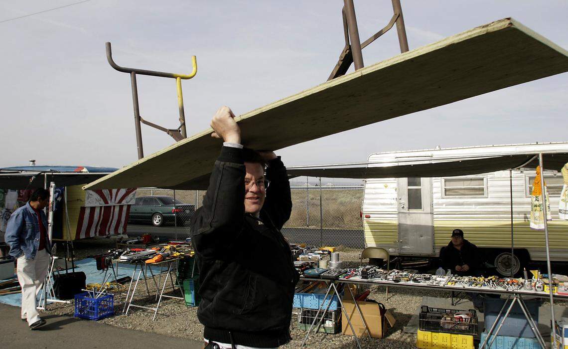 Bill Robinson, owner and founder of the Pasco Flea Market, carries a table to a vendor stall on a busy weekend in 2008 at the east Pasco site.