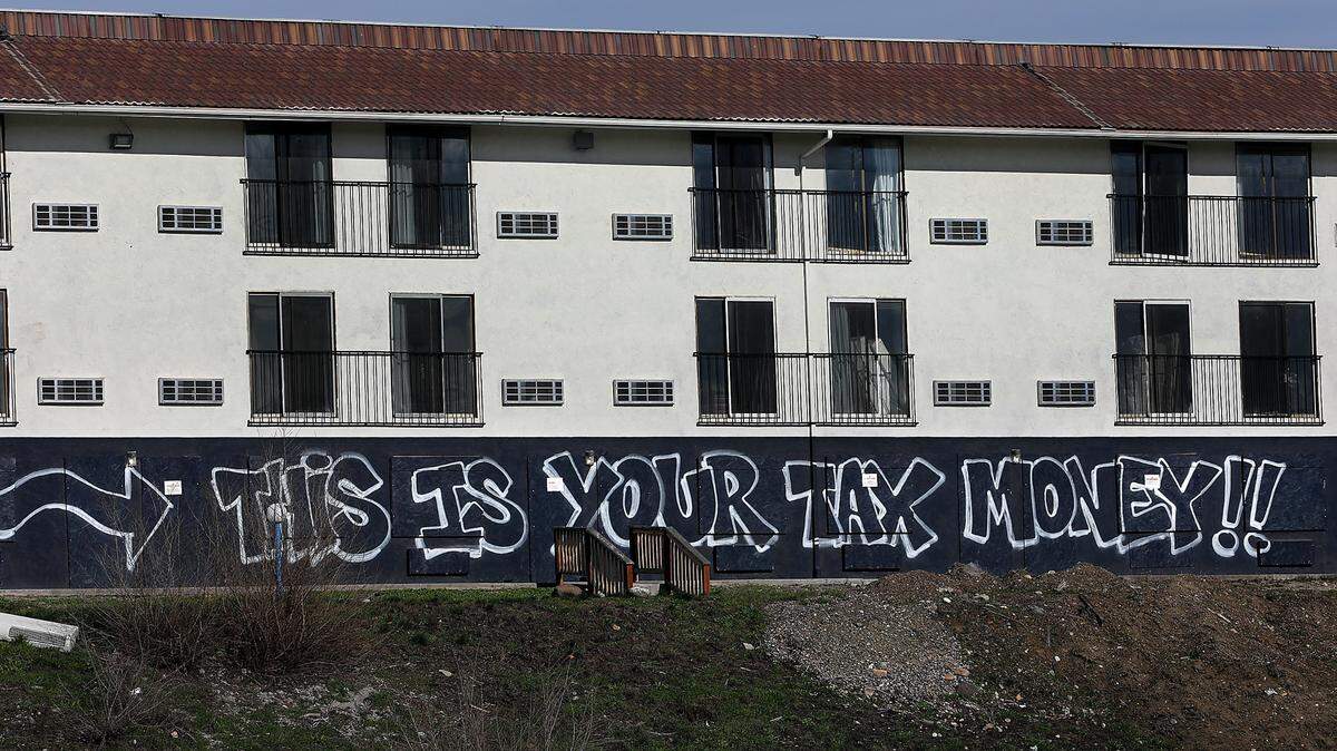 A graffiti message is scrawled across the boarded up former Motel 6 building off West 2nd Avenue near Highway 395 in Kennewick.