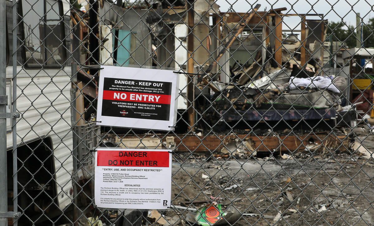 A temporary construction fence surrounds the burned remnants of the "junkyard" house at 2100 Pullen St. in Richland. Signs attached, by the fire marshal and building services officials, to the chain link perimeter warns of the dangers of entry and trespassing.