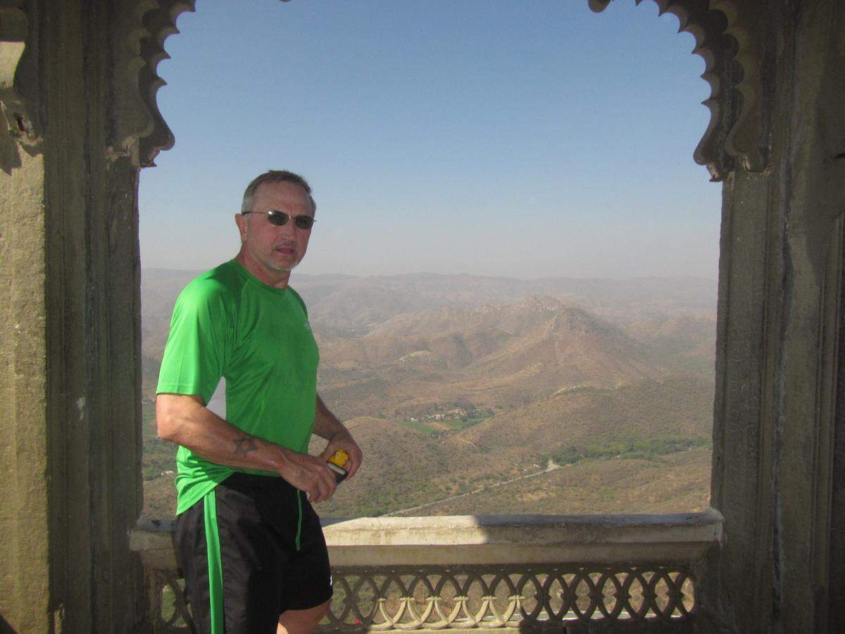 After completing his run up Bansdara Peak, India, Micah Smith stands at Monsoon Palace overlooking the valley below.