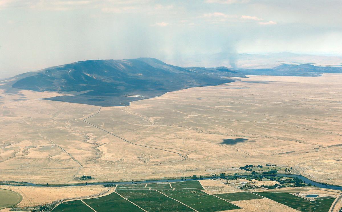 The east face of Rattlesnake Mountain still smolders Friday morning in this aerial photo taken from about 4,000 feet that also shows the Yakima River just upriver of the Wanawish Dam.