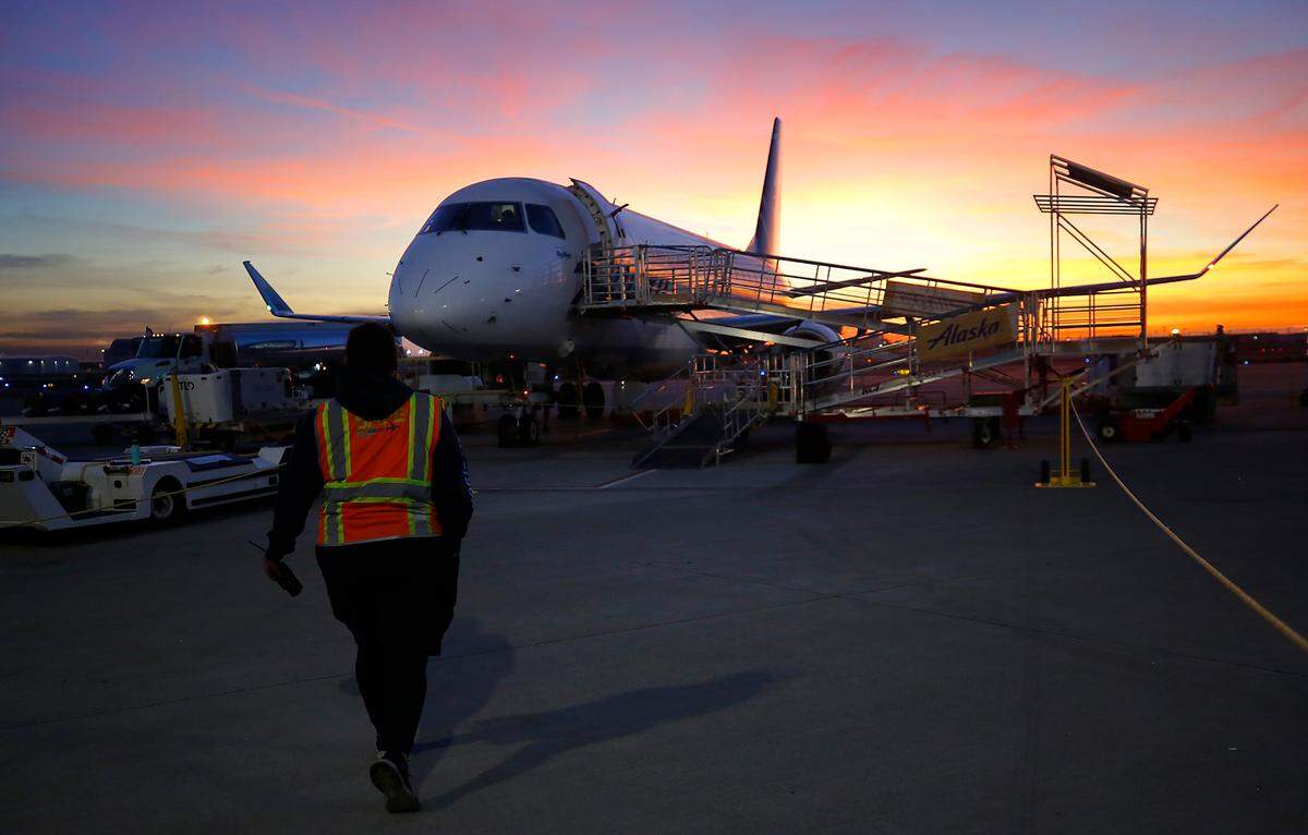A ground crew member for Alaska Airlines walks the tarmac as the airline debuts its new daily flight Tuesday morning between the Tri-Cities Airport and LAX. The 76-seat Embraer carried 48 passengers plus crew and departed shortly after sunrise.