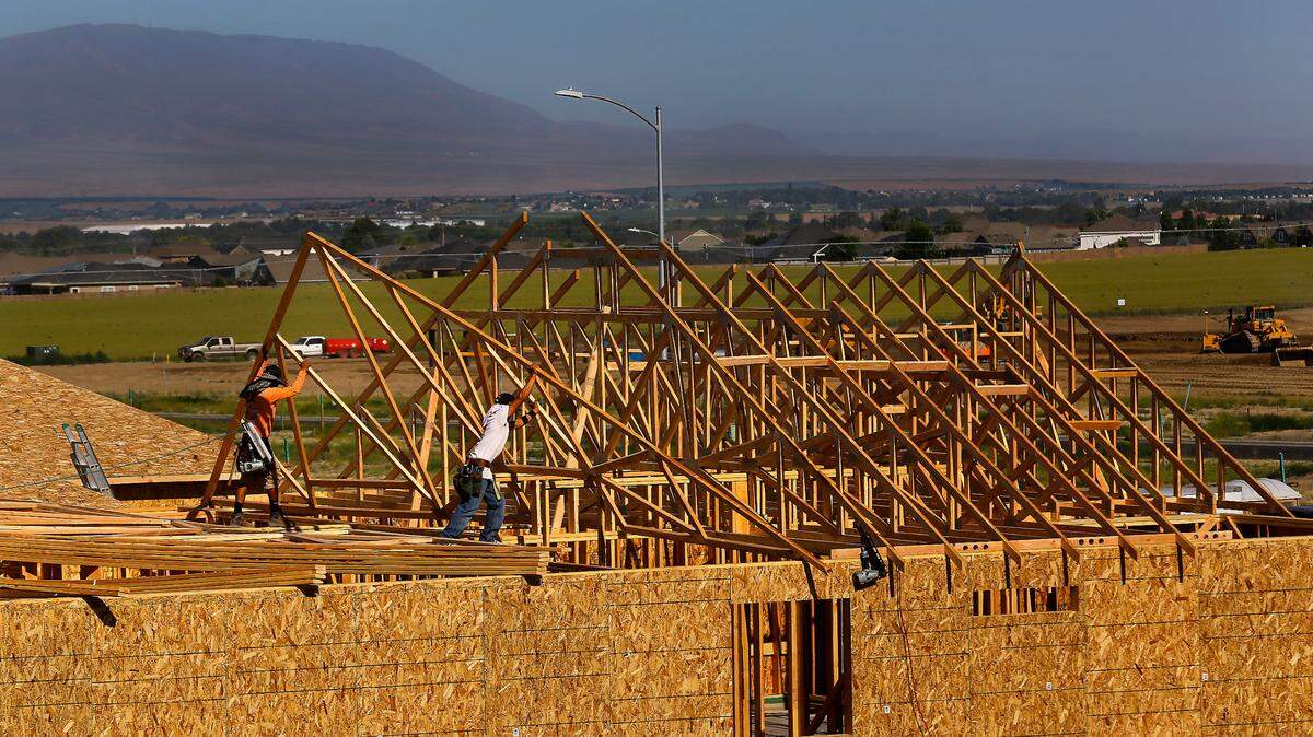 Constructions crews install roof trusses on a new under construction in the Barker Ranch housing development by Pro Made Homes off Road 104 in west Pasco. 