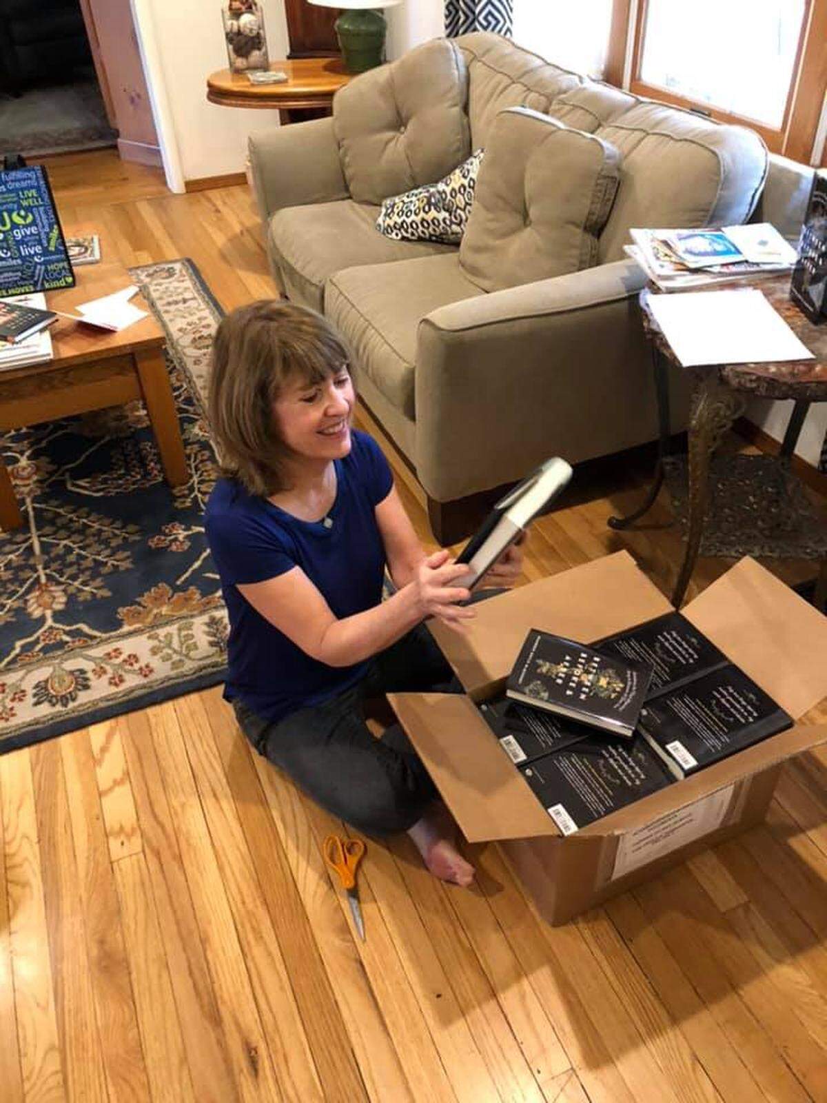 Author Maureen McQuerry opening a shipment of her new novel, ‘Between Before & After.’