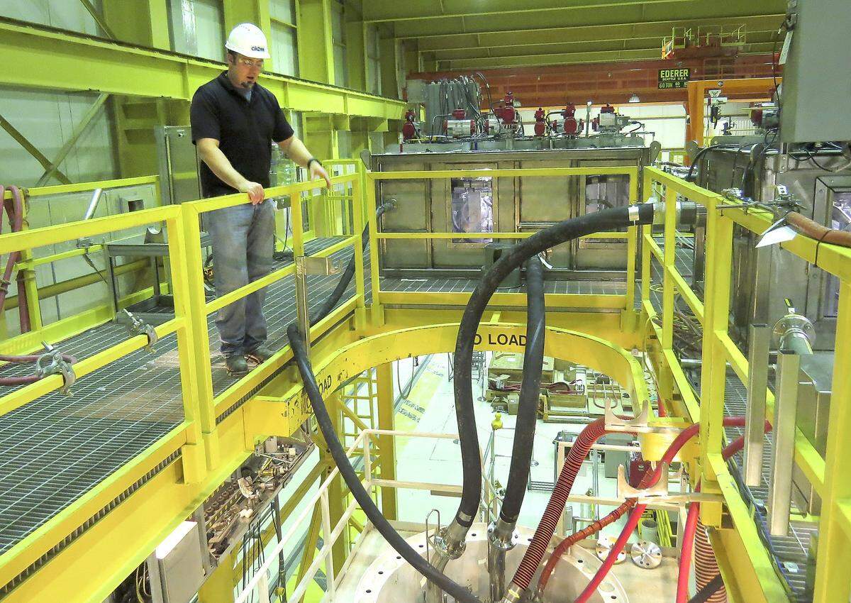 A workers stands on a platform above a storage container being commissioned with mock, nonradioactive sludge. The container now will be used to store radioactive sludge as it is removed from underwater containers at Hanford's K West Basin near the Columbia River.