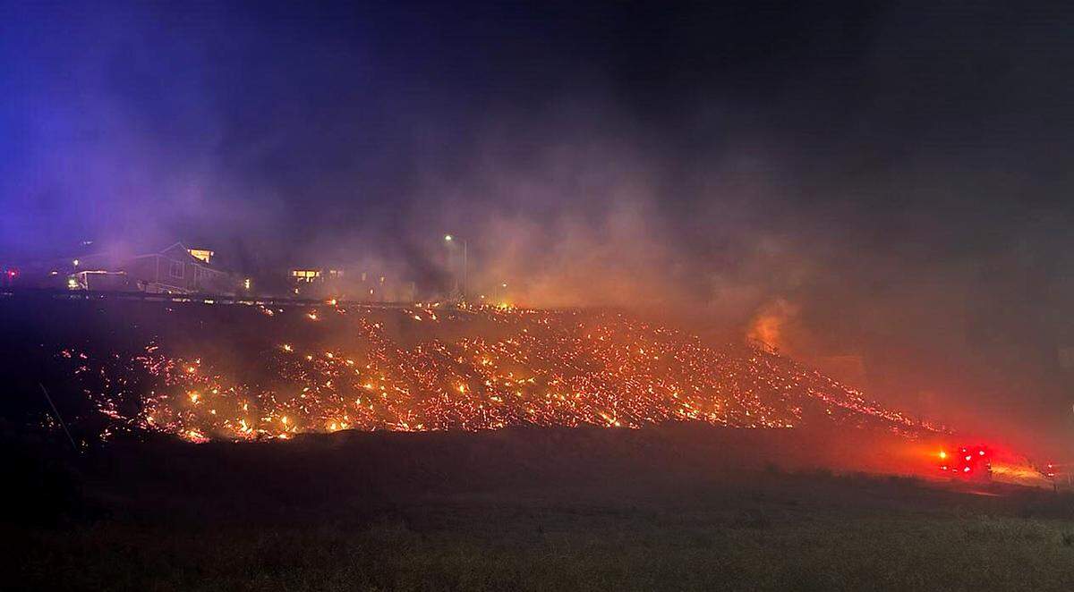 Firefighters work to extinguish a natural cover fire overnight in the area of West 42nd Ave and South Union Street in Kennewick.
