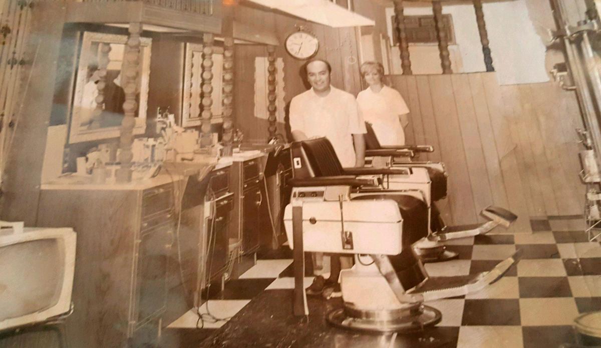 Barber Larry Maltos, left, and an employee named Delpha pose for a photo inside LM Barber Shop in the late 60’s or early 70’s.
