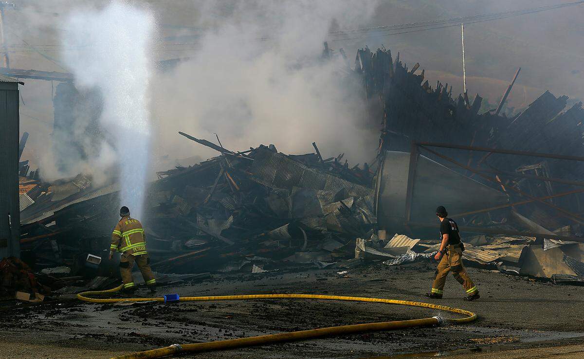 A smoldering pile of twisted metal and charred lumber is all that remains Thursday morning of the M & E Seed and Grain Co. in downtown Prosser after firefighters battled the fire all night. The blaze reportedly left one person with burns.