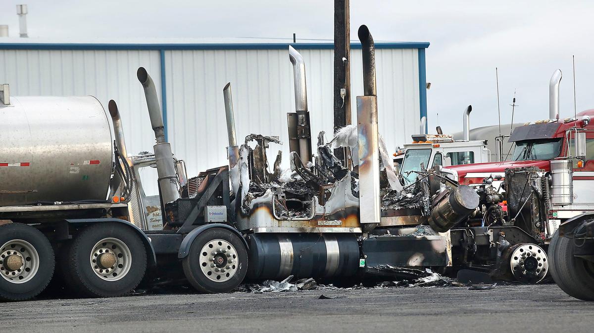 Seven semi truck cabs destroyed in a chain-reaction fire Saturday night sit Monday in the parking lot of the Harms Pacific Transport north of Pasco.