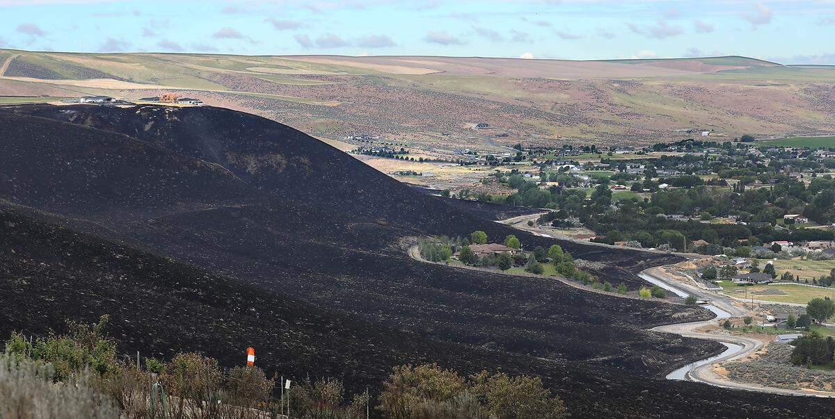 The land around houses on the top of Badger Canyon is scorched from the natural cover fire that windy conditions pushed across nearly 1,700 acres.