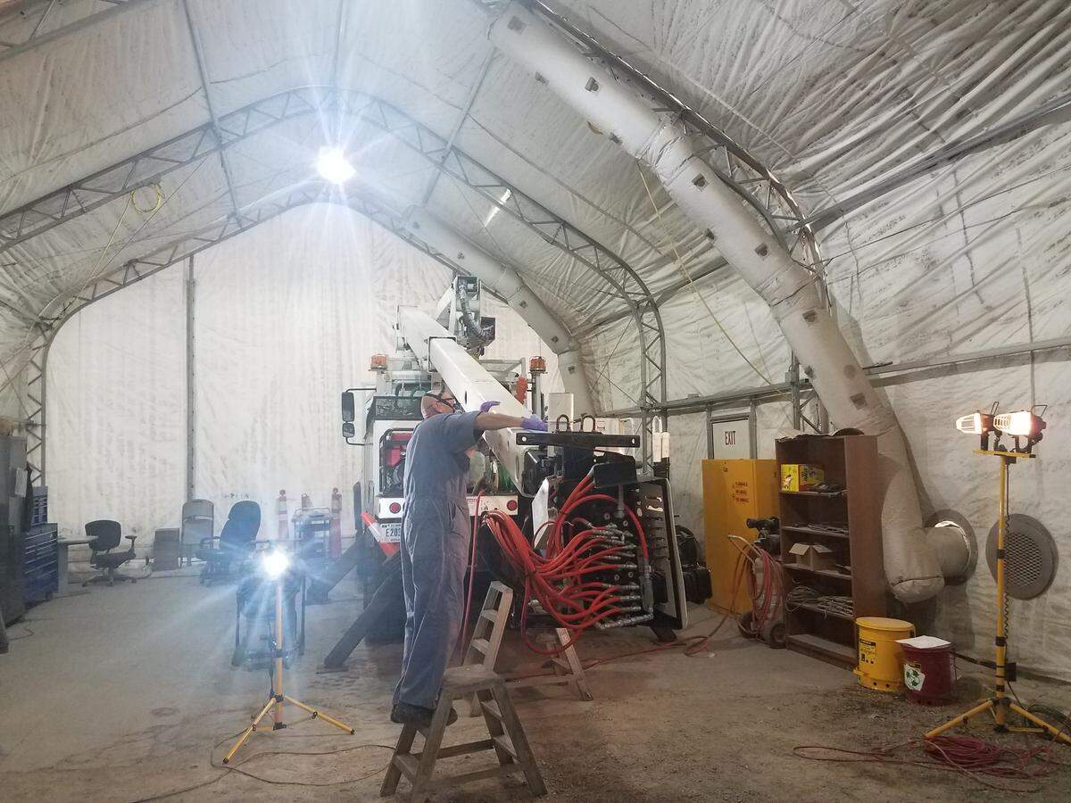 A Mission Support Alliance auto body worker at the Hanford Site prepares an electrical utilities bucket truck boom for refinishing.