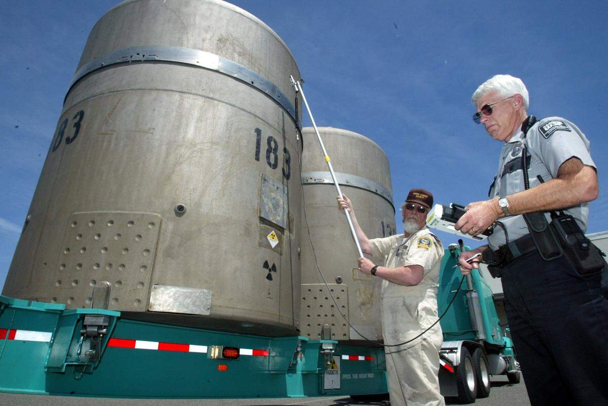 Officials with the Washington State Patrol and the Oregon Department of Transportation measure the radiation levels of containers holding 55-gallon drums of transuranic waste being shipped from Hanford to New Mexico in 2003.