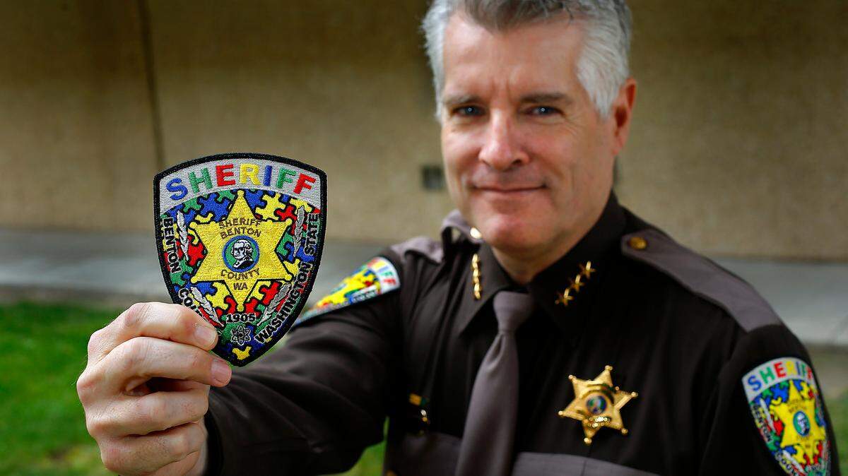 Benton County Sheriff Tom Croskrey shows the special patch the law enforcement agency created as a fundraiser during Autism Awareness month. 