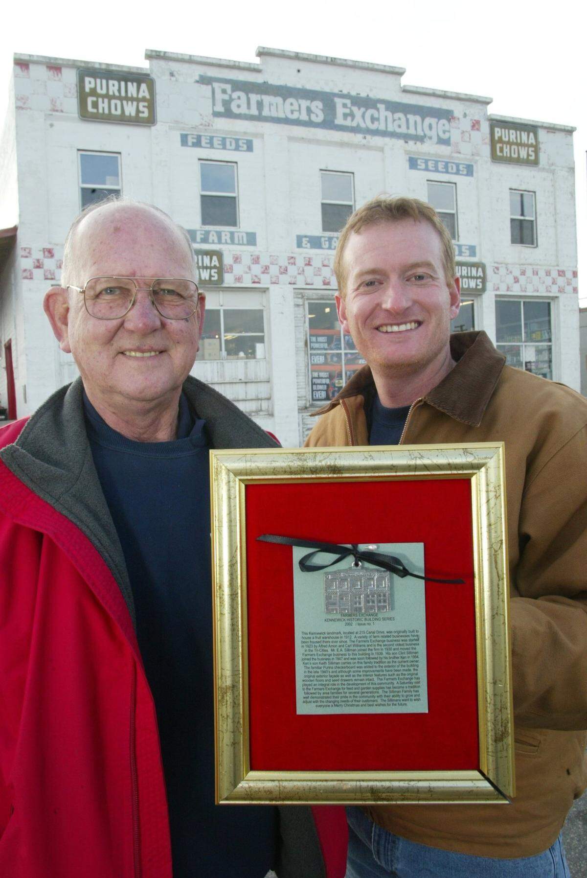 In this 2002 file photo, Ken Silliman, left, and his son Keith hold a version of a commemorative Christmas ornament featuring their store, Farmers Exchange.