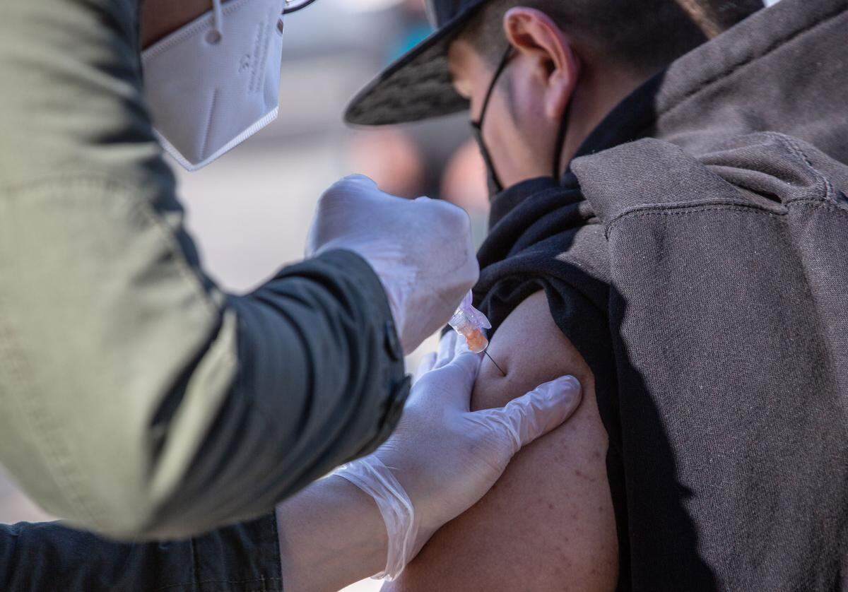 Pharmacist Johnny Nguyen administers a dose of COVID-19 vaccination to one of about 375 Douglas Fruit workers Friday during a pop-up clinic outside of the company’s Pasco facility. The agricultural producer partnered with the Washington State Tree Fruit Association and Safeway/Albertsons to administer Johnson & Johnson’s Janssen single-dose vaccine to employees.