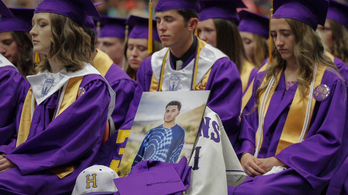Hanford High School students and staff take a moment of silence to honor their classmate Dmetri Kennedy-Woody during the commencement ceremony at the Toyota Center.