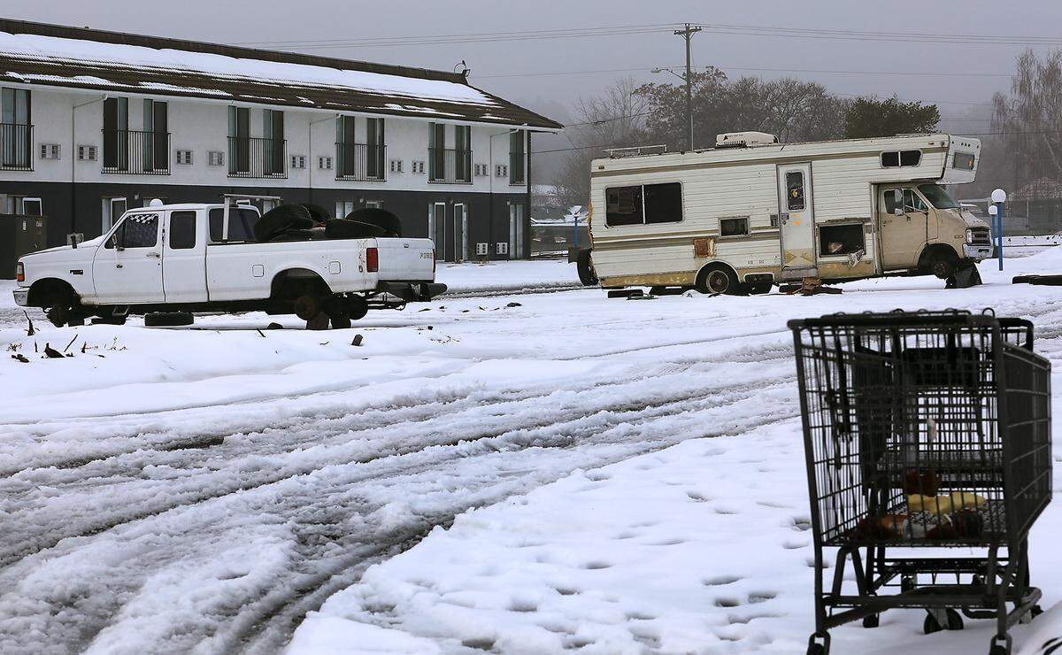 Derelict vehicles and a misplaced shopping cart sit in the main parking lot of the former Motel 6 off West 2nd Avenue at Highway 395 in Kennewick.. City officials say they hired a contractor to secure the vacant property after the property owner failed to.