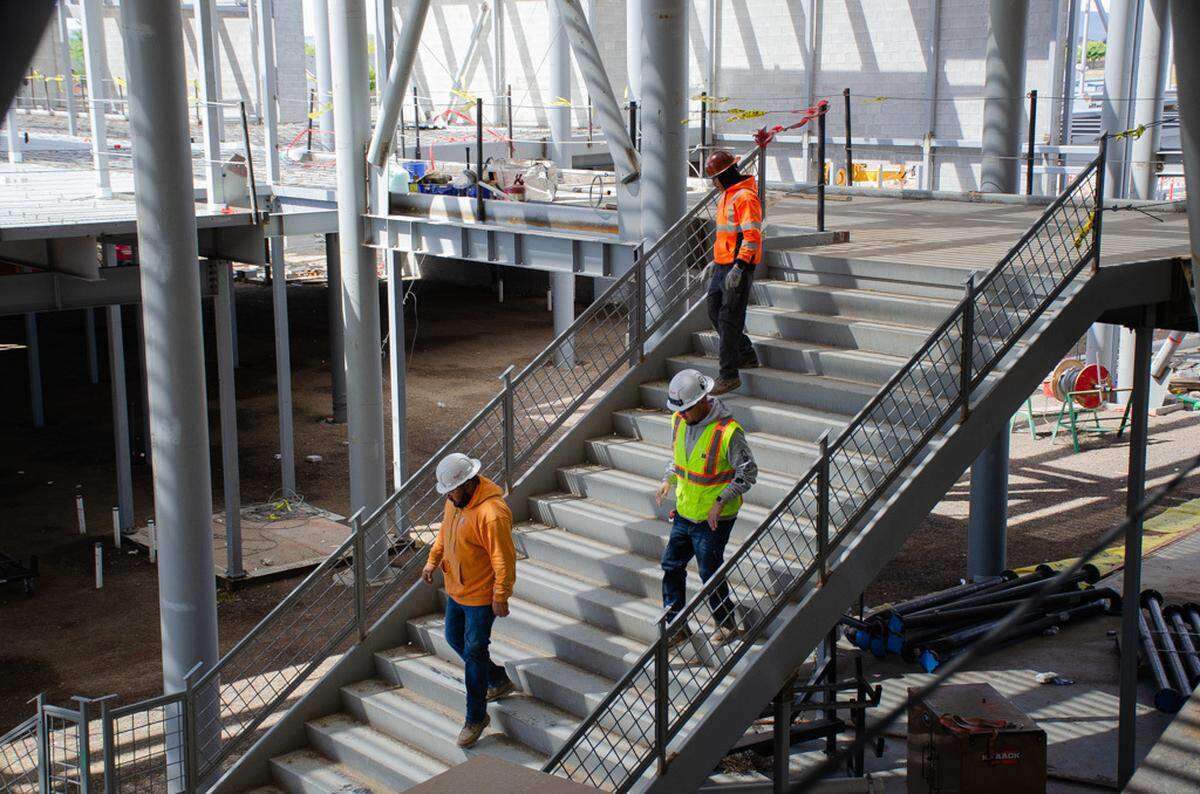 Construction workers walk down to the first floor inside the new Sageview High School being built at 6091 Burns Road in Pasco, Washington. The project to build a new 300,000-square-foot school is nearly 50% complete.