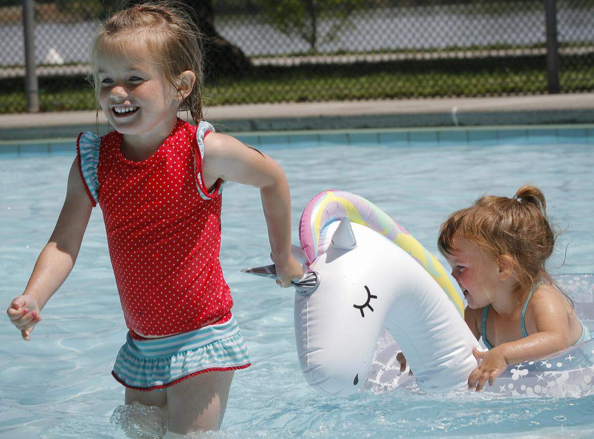 Lillian Constance, 5, pulls a unicorn floatie with her little sister, Autumn, 2, at the wading pool at Howard Amon Park in Richland in 2018. They were with their mother, Heather Constance of Richland. 