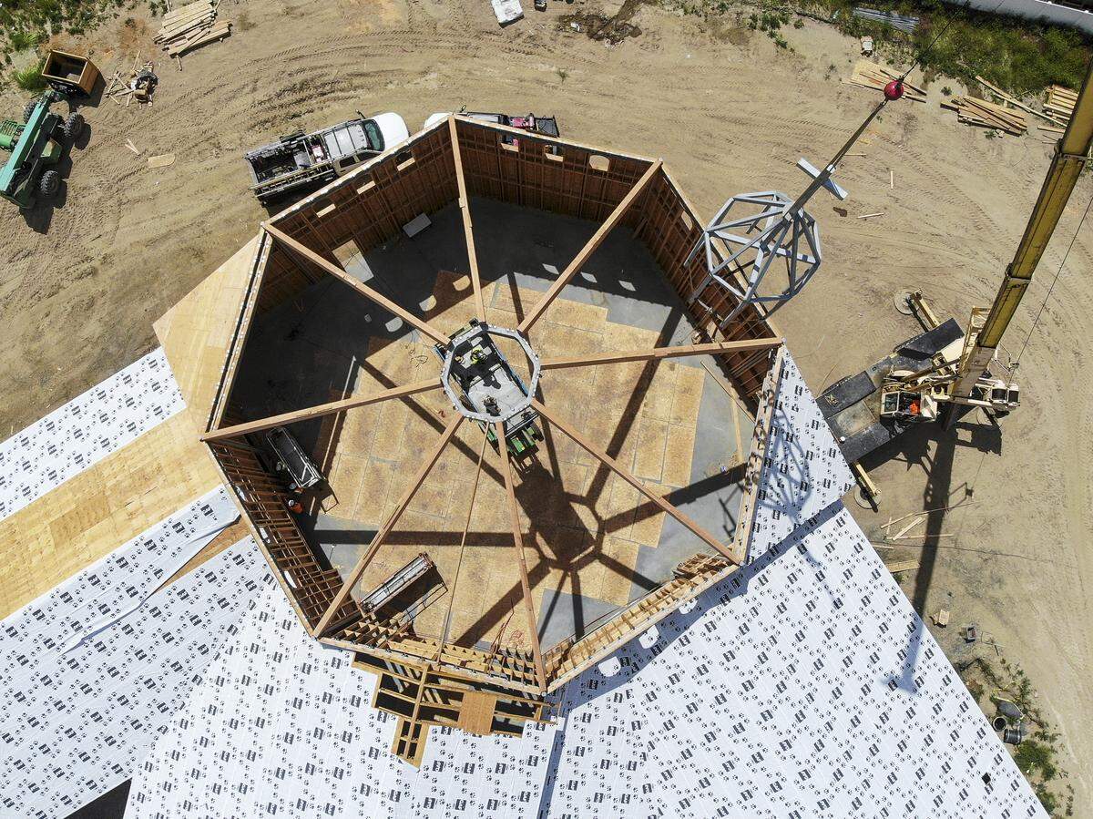 Workers use a crane to lift a 7,600-pound metal steeple to the top of Southridge Church under construction in west Kennewick.