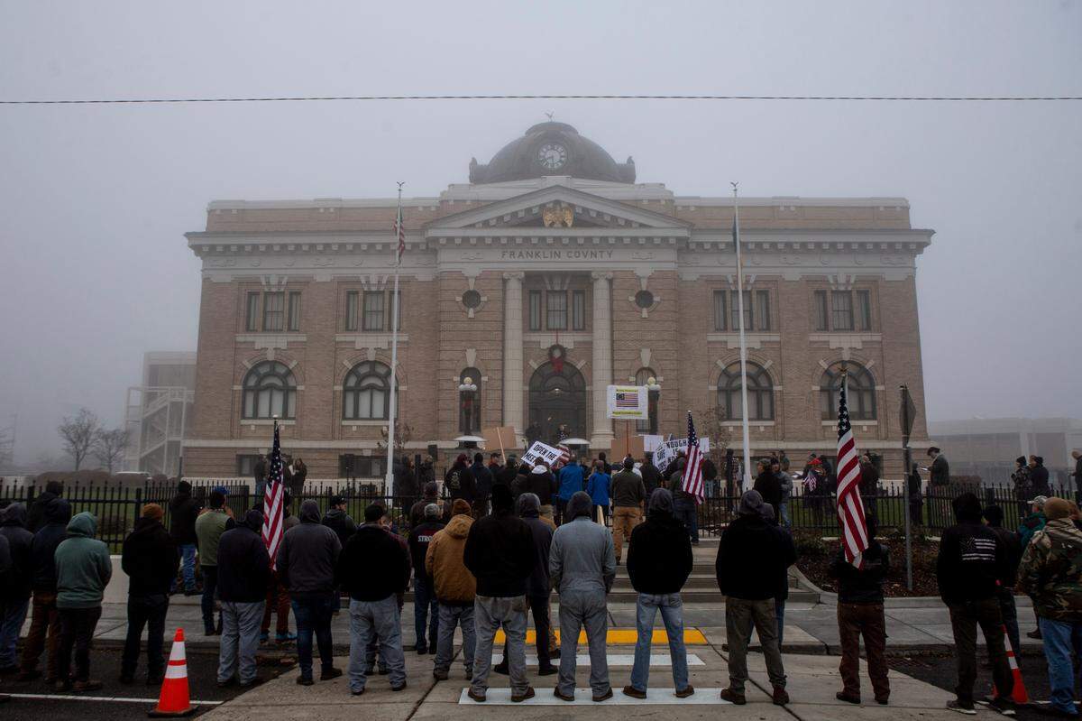 Supporters for ending the Washington state coronavirus restrictions gather outside of the Franklin County Courthouse in Pasco on Tuesday.