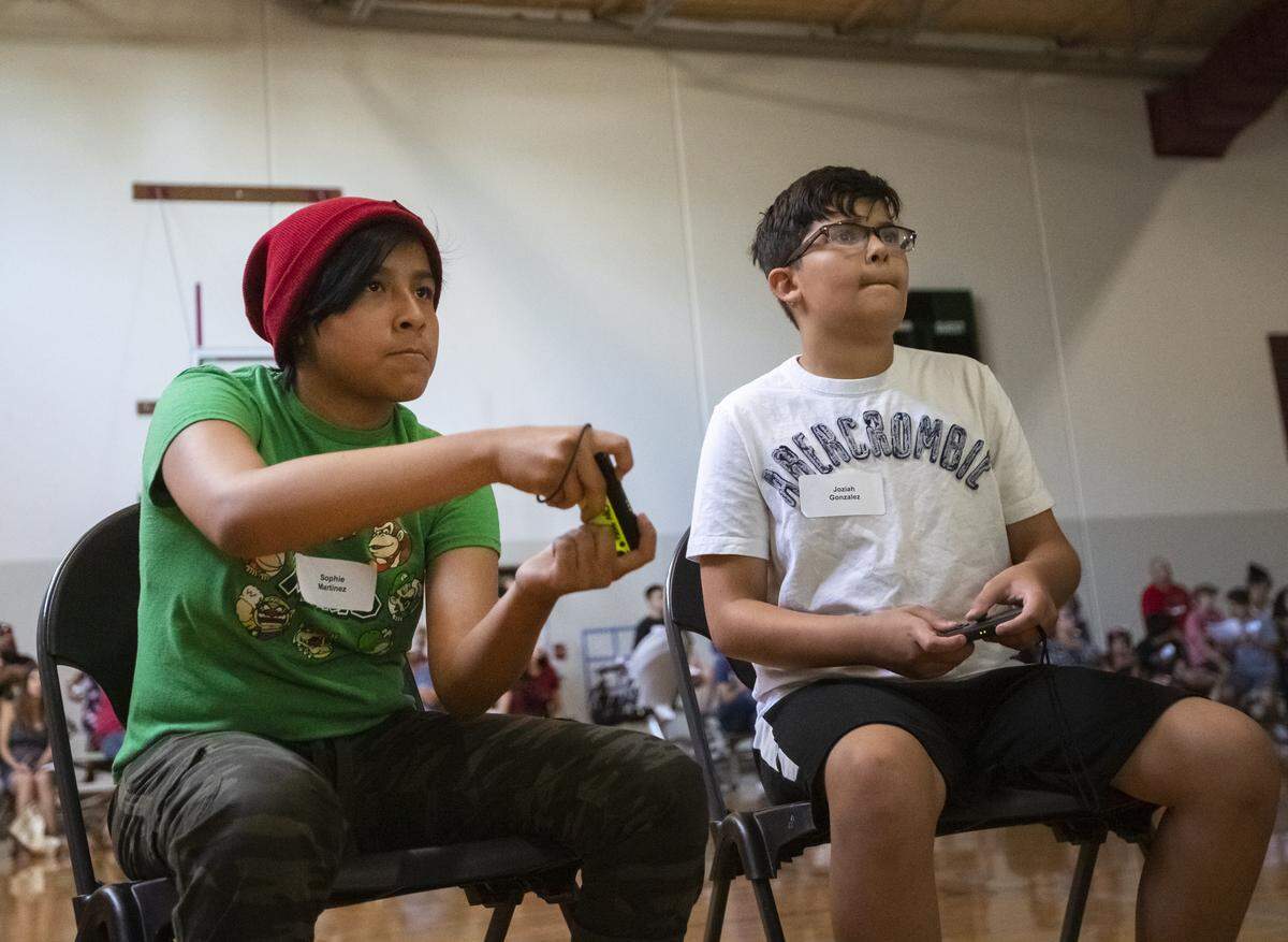 Sophie Martinez, left, and Josiah Gonzalez compete in the Nintendo Switch Mario Kart tournament inside Pasco’s gym on Saturday. It is the first EGaming tournament the City has put on.