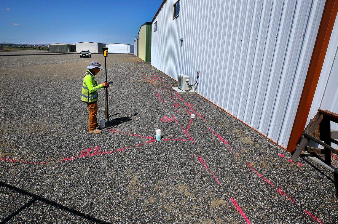 Mark Villa, of Geophysical Survey in Kennewick, maps out underground lines he marked with paint by using ground penetrating radar inside the fenced hangar area at the Port of Benton’s Richland Airport.