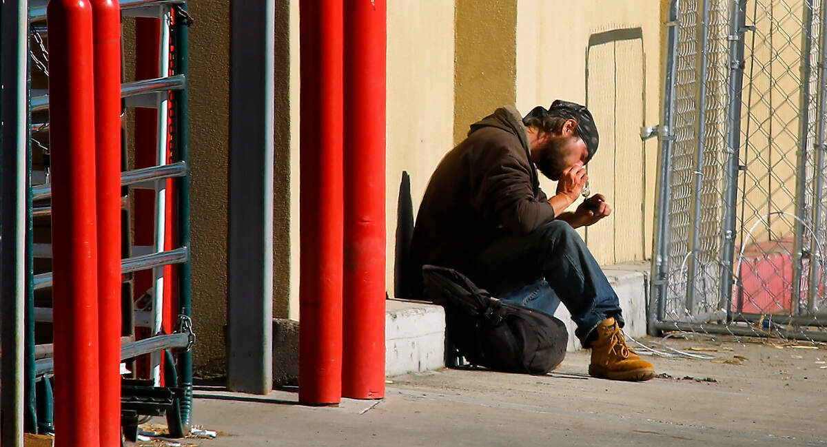 Suspect Kerry Brooks appears to smoke an unknown substance from a glass pipe Wednesday morning in the parking lot of Ranch & Home store on Columbia Center Boulevard in Kennewick during a standoff with police. Police say Brooks entered the store brandishing a knife demanding employees sell him a firearm. He was later safely taken into custody.