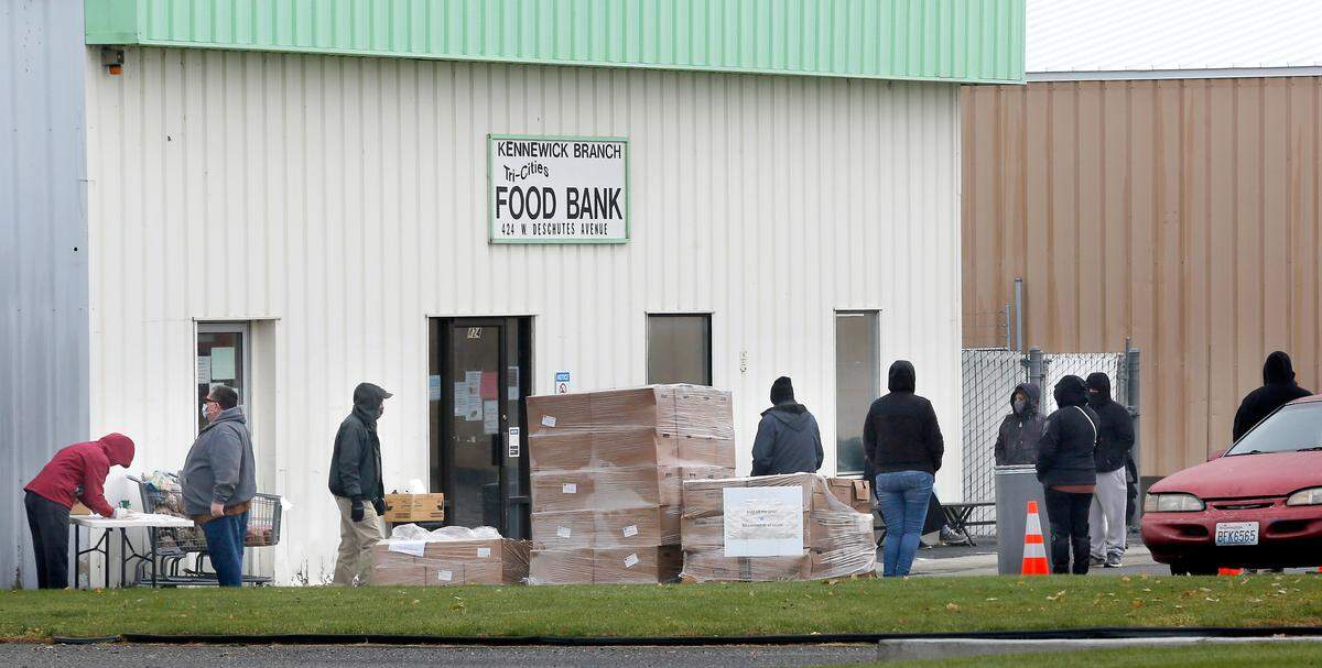 Volunteers and clients line up in the parking lot of the Kennewick branch of the Tri-Cities Food Bank Thursday morning in preparation for a food box distribution during the ongoing coronavirus pandemic. Food bank officials say they’ve served more than 140,000 people in need during the COVID pandemic.