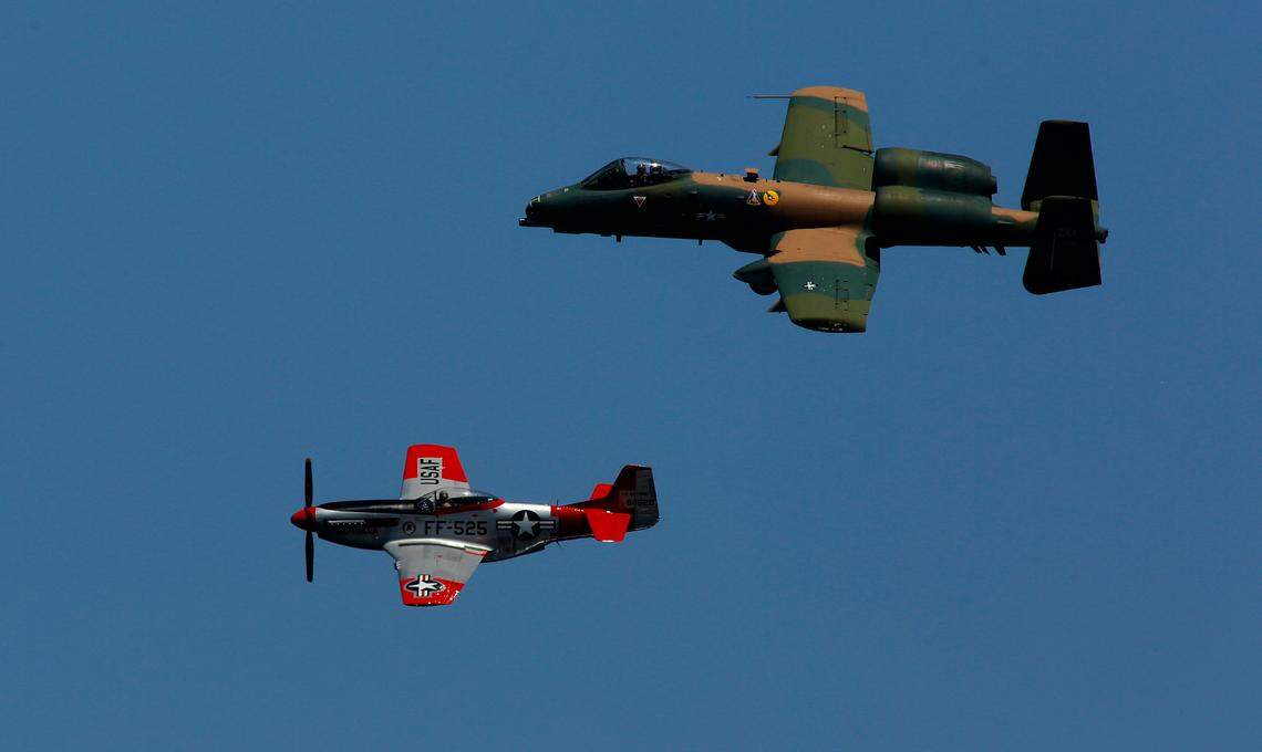 A World War II vintage P-51 Mustang fighter airplane and a modern United States Air Force A-10 jet fighter fly in formation over the Columbia River during the Over the River Air Show at Water Follies