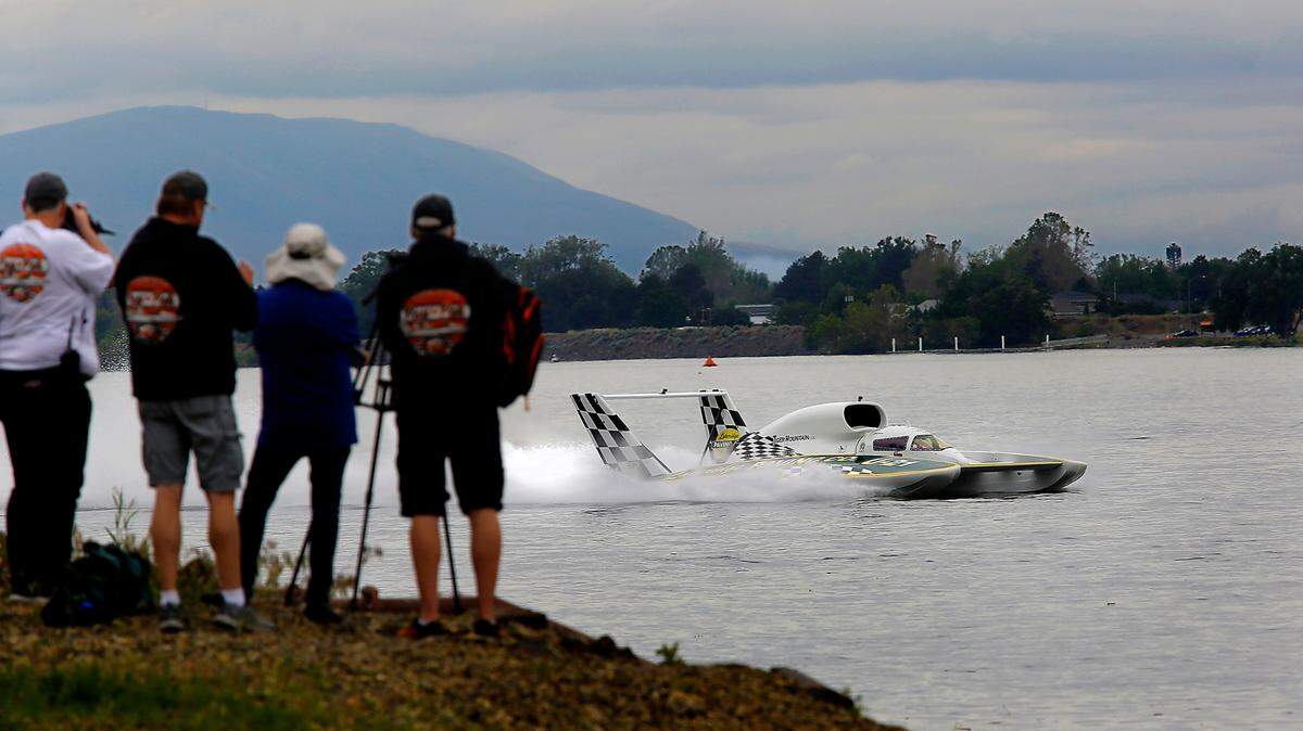 The U-21 Miss Lakeridge Paving unlimited hydroplane being driven by Brian Perkins zips past racing fans on the Kennewick shoreline on the way back to the pits on an overcast Friday morning following his first test run of the spring testing day on the Columbia River.