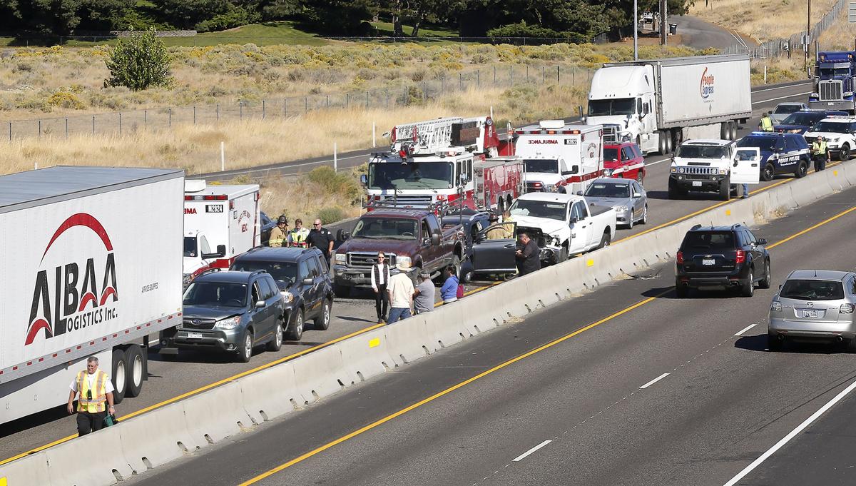 Drivers, passengers, police and firefighters stand around damaged vehicles Monday morning in the southbound lanes of Highway 395 near the Court Street overpass in Pasco. The six-car, chain-reaction collision behind a semi-truck and tractor clogged the lanes heading toward Kennewick. Traffic was backed up while the scene was cleared.